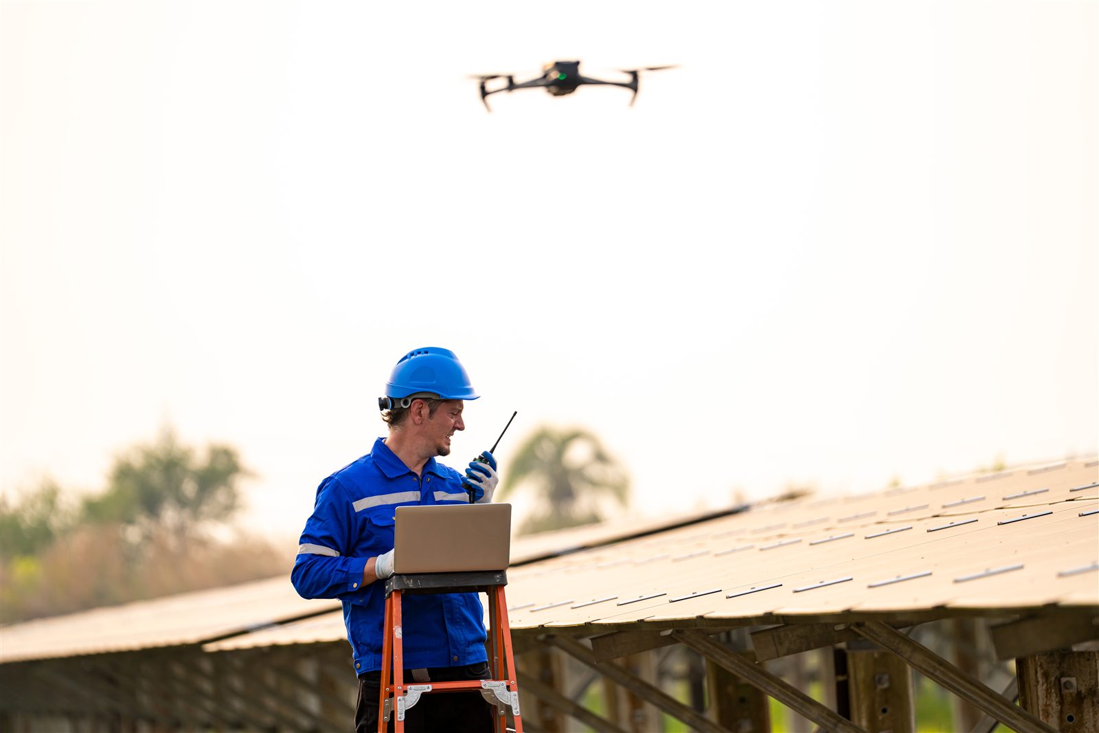 Inspection pilot flying a drone over solar panels